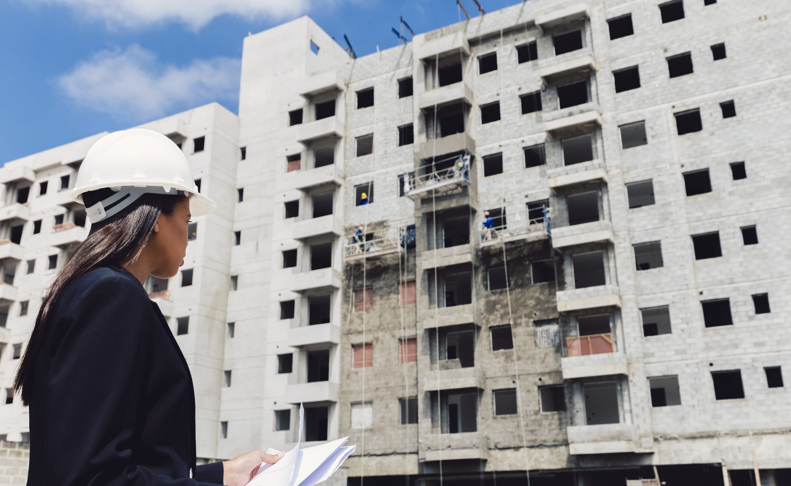 african american lady safety helmet with papers near building construction