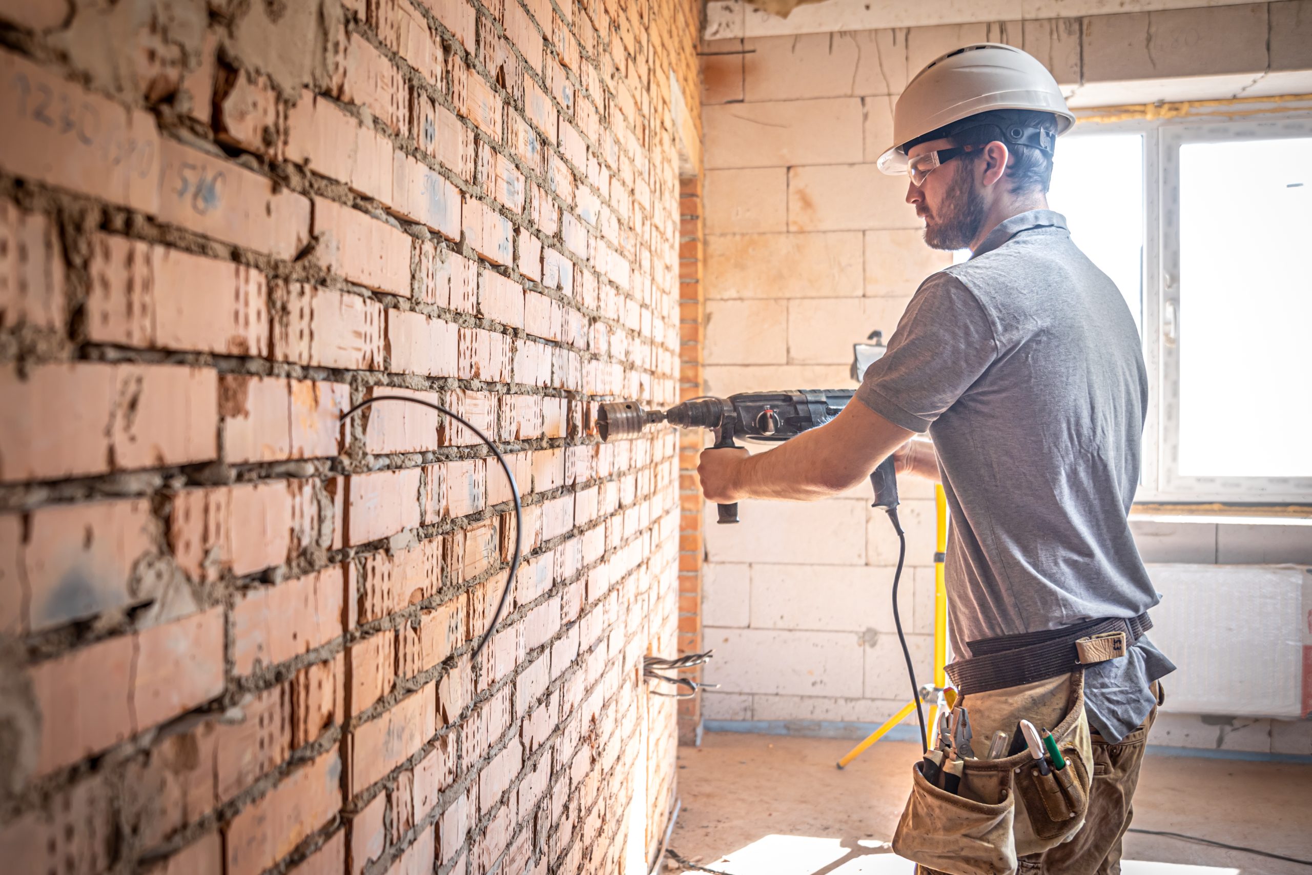 handyman construction site process drilling wall with perforator